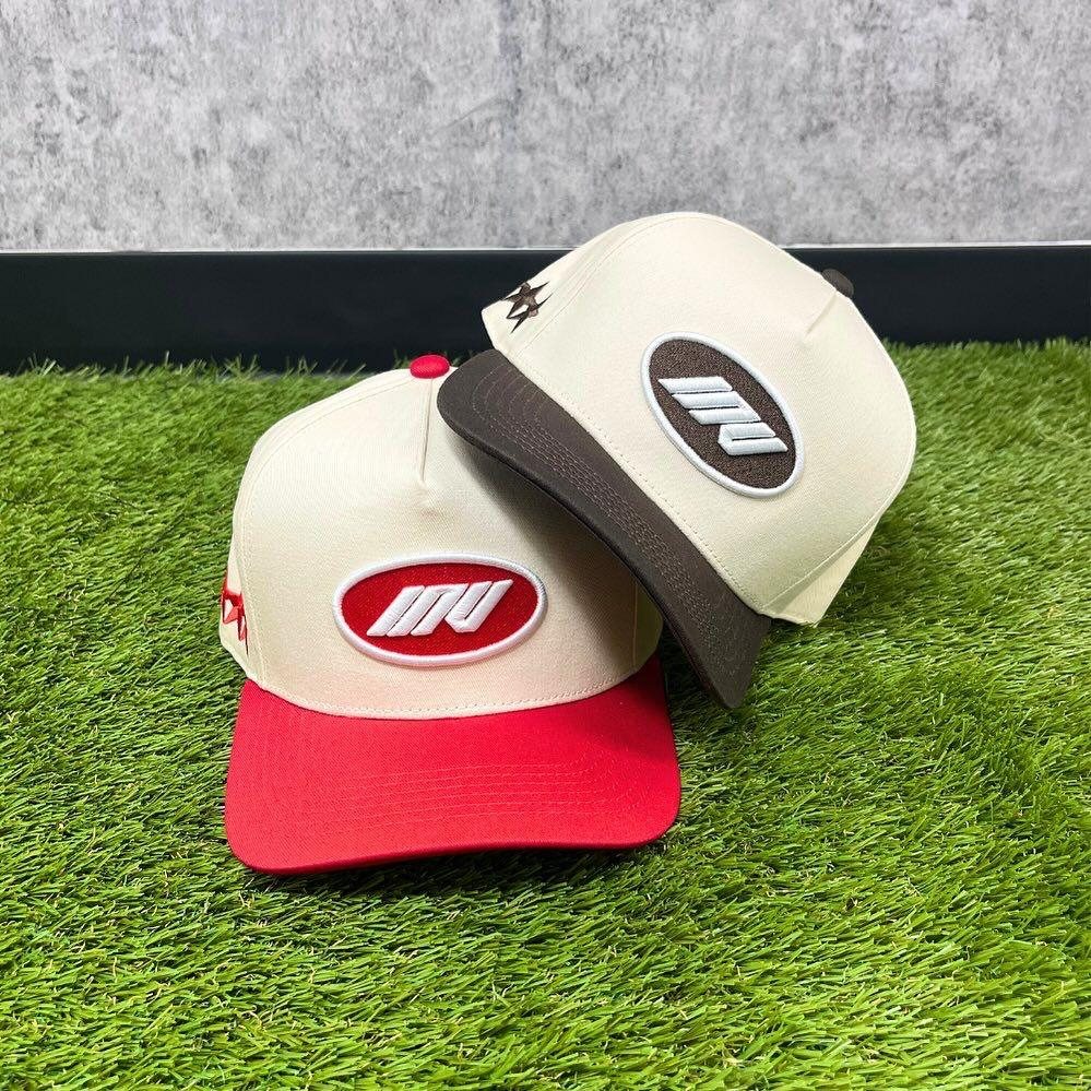 Custom cream trucker caps with red and brown brims and oval patches